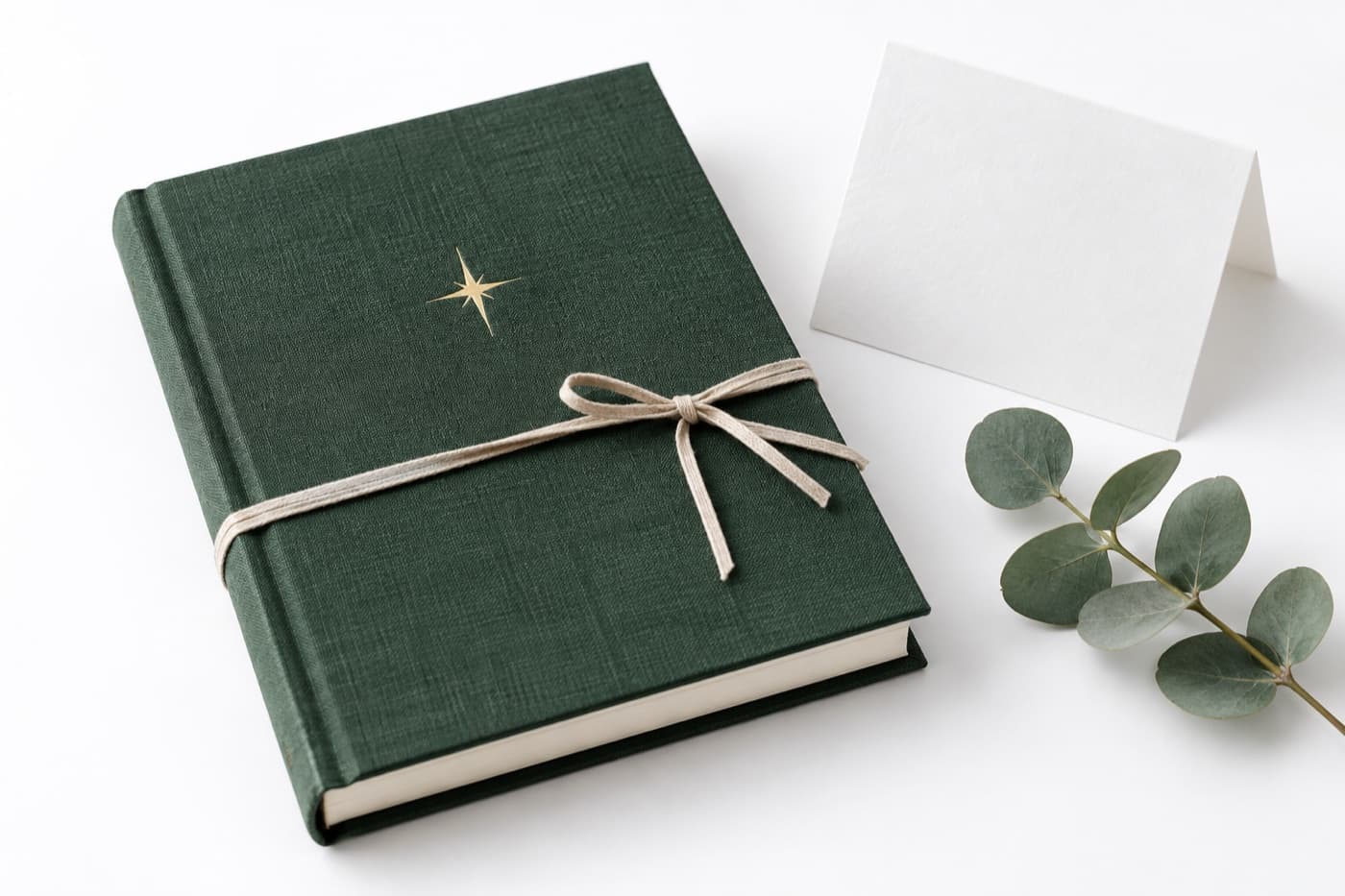 A green linen Tala book tied with a ribbon, with a card